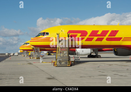 Eine Reihe von gelben und roten DHL Boeing 757-200 SF Frachtflugzeugen Parken am Flughafen Leipzig in Deutschland Stockfoto