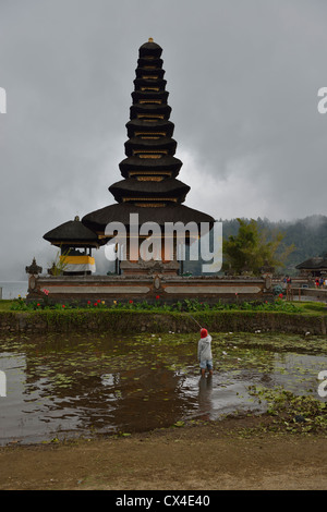 Kinder Angeln neben dem Meru Danau Bratan an einem bewölkten Tag; Bali, Indonesien. Stockfoto