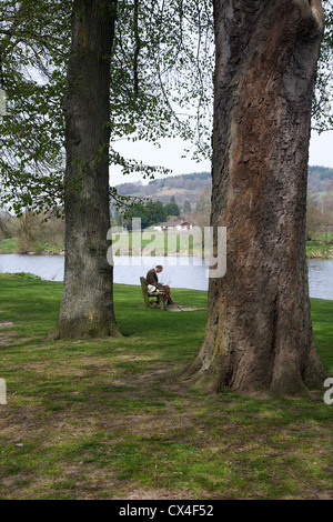 Alter Mann auf einer Bank am Builth Wells, Powys, Wales, UK Stockfoto