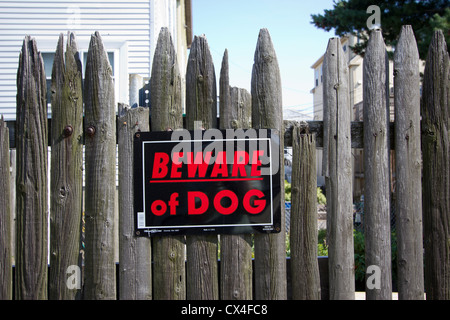 Vorsicht bei Hund Schild auf einem alten verwitterten hölzernen Palisade Zaun Stockfoto