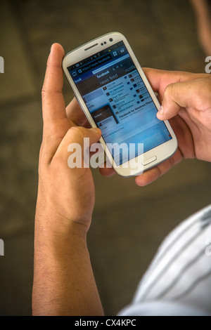 Ein Smartphone-Benutzer auf Facebook im Internet zugreift. Stockfoto