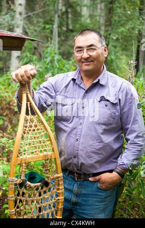 Robert Grandjamber eine erste Nation Canadian living in Fort Chipewyan, mit seinen Schneeschuhen Stockfoto