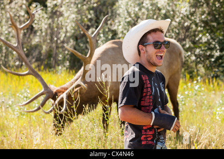 Ein Tourist mit einem zahmen Elche in den kanadischen Rocky Mountains in der Nähe von Jasper. Stockfoto