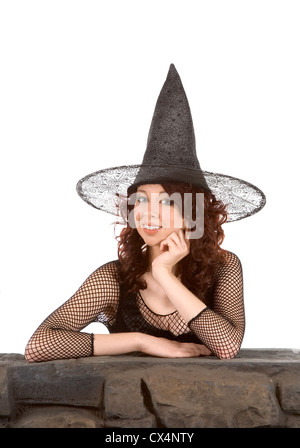 Porträt von Latina Teenager Mädchen in schwarz Halloween Hut und Netzstrümpfe Kleid von Steinzaun Stockfoto
