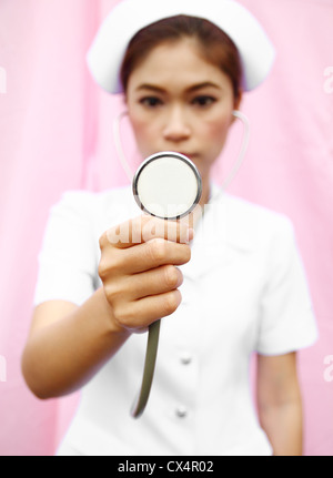 Junge Krankenschwester mit Stethoskop cheking Stockfoto