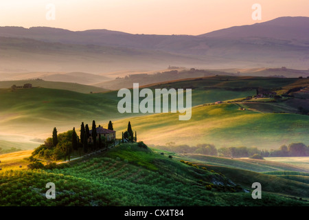 Farytale Sonnenaufgang in der Toskana. Bauernhaus, Zypressen und den Hügeln des Val d ' Orcia Stockfoto