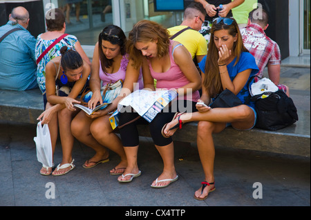 Junge Frauen Touristen saßen auf Bank Karte auf Straße in Barcelona Katalonien Spanien ES zu studieren Stockfoto