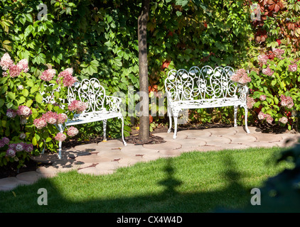 Weiße Bänke im Sommergarten Stockfoto