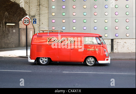 Leuchtend rote VW Oldtimer Wohnmobil van cool Flo unterwegs im städtischen Umfeld Stockfoto