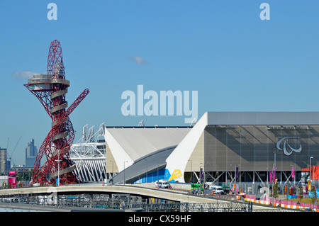 London 2012 Olympic Park vista mit Orbit Tower, Teil des Hauptstadions und dem Logo der Paralympischen Spiele auf dem Aquatics Center mit temporären Tribünen Stockfoto