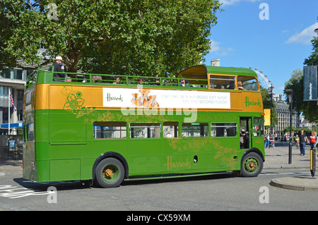 Touristen auf Harrods open top Classic konvertiert Routemaster Bus Sightseeing in London auf einem blauen Himmel Sommer Tag London Eye über England Großbritannien Stockfoto