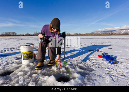 Eisangeln Sie auf McWenneger Slough mit Schwan-Bergen im Hintergrund in der Nähe von Kalispell, Montana, USA. (MR) Stockfoto