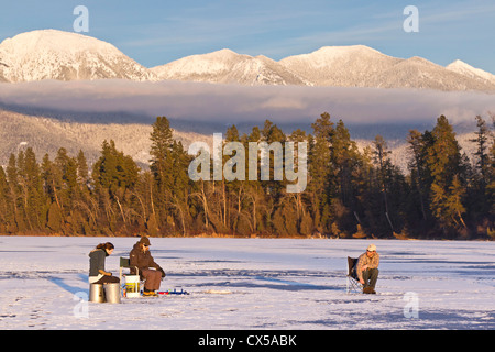 Eisangeln Sie auf McWenneger Slough mit Schwan-Bergen im Hintergrund in der Nähe von Kalispell, Montana, USA. (MR) Stockfoto