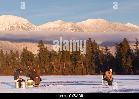 Eisangeln Sie auf McWenneger Slough mit Schwan-Bergen im Hintergrund in der Nähe von Kalispell, Montana, USA. (MR) Stockfoto