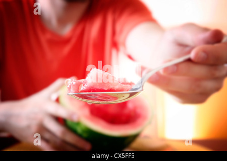 Mann isst ein Stück Wassermelone. Stockfoto