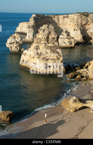 ALGARVE, PORTUGAL. Ein junges Paar zu Fuß entlang einem einsamen Strand in Marinha in der Nähe von Praia Carvoeiro. 2012. Stockfoto