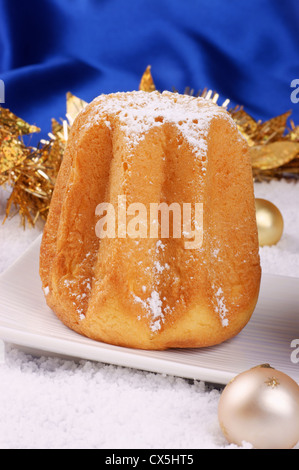 Weihnachten-Zusammensetzung vor einem hellen blauen Hintergrund: Pandoro, ein typisch italienischer Weihnachtskuchen und Weihnachtsschmuck Stockfoto