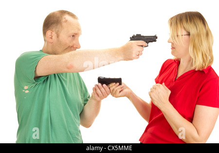 Ein Mann eine Frau mit vorgehaltener Waffe zu halten Stockfoto