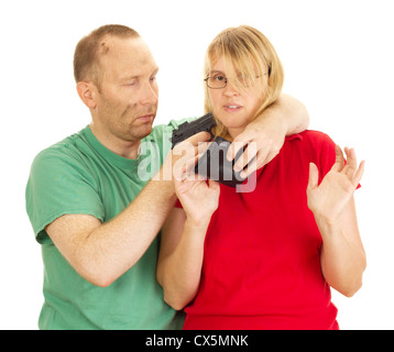 Ein Mann eine Frau mit vorgehaltener Waffe zu halten Stockfoto