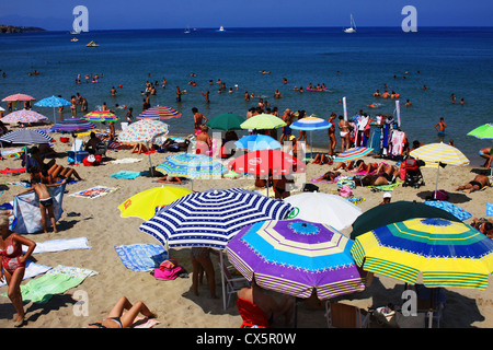 Personen, sonnigen Tag auf überfüllten Strand gelegen, in der Nähe der Altstadt von Cefalu (Sizilien). Stockfoto