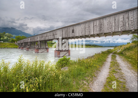 Eine alte, hölzerne, überdachte Brücke überspannt einen Fluss an der Grenze zwischen der Schweiz und Lichtenstein Stockfoto