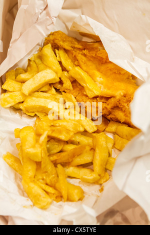 Traditionsgemäß gebratenen Fisch und Chips, eingewickelt in Papier servierbereit Stockfoto