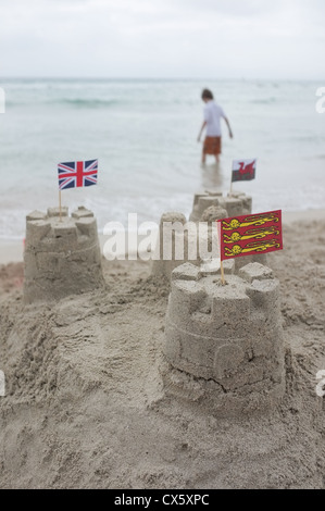 Sandburgen bauen mit britischen Flaggen in an einem Strand an einem bewölkten Tag mit der schottischen Flagge im Vordergrund Stockfoto