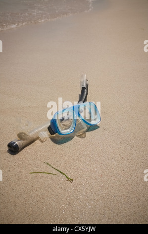 Ein Schnorchel Maske in den goldenen Sand und das Meer an einem Strand in der Sonne liegen Stockfoto
