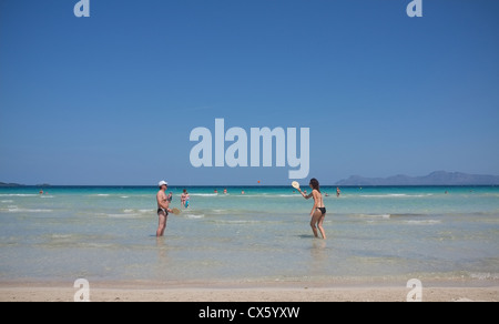 Strandurlauber spielen Tennis am goldenen Sandstrand von Alcudia Beach in Mallorca Stockfoto