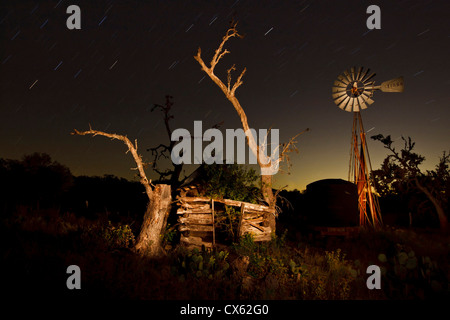 Sternspuren, alte Blockhütte und Windmühle, Block Creek Natural Area, Texas Stockfoto