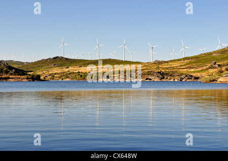 Windmühle mit mehreren Windkraftanlagen in der Nähe eines Flusses, grüne Energie produzieren. Stockfoto