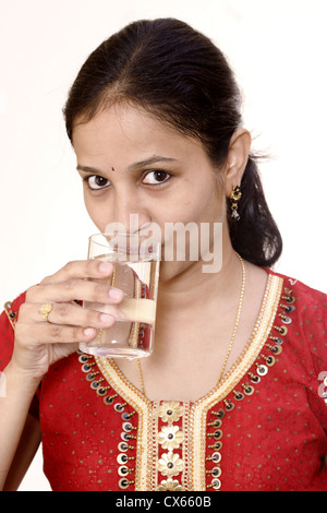 Junge Frau Trinkwasser vor weißem Hintergrund Stockfoto