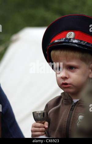 Junge in uniform Mütze von Don Kosaken aus metallischen Becher trinken Stockfoto