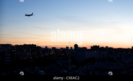 Flugzeuge fliegen über Lissabon bei Sonnenuntergang Stockfoto