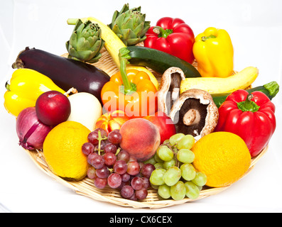 Ein Korb voll von verschiedenen Obst und Gemüse auf einem weißen Hintergrund. Stockfoto