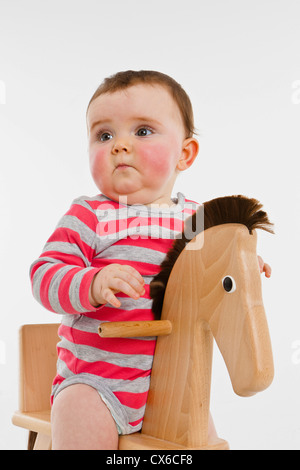 Ein kleines Mädchen auf einem Schaukelpferd Stockfoto