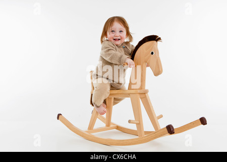 Ein kleines Mädchen auf einem Schaukelpferd Stockfoto