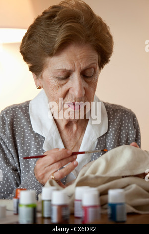 Eine ältere Frau, die Malerei auf Stoff Stockfoto