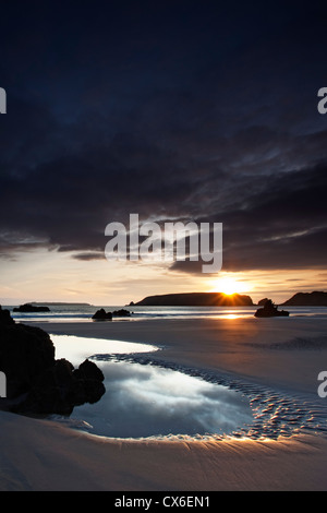 Die Sonne versinkt über Marloes Strand in Pembrokeshire, Wales UK Stockfoto