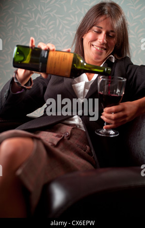Geschäftsfrau, entspannend und gießen Glas Rotwein Stockfoto