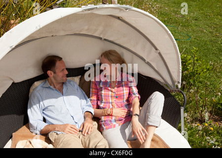Ein paar liegen in einer Cabana in ihrem Hinterhof Stockfoto