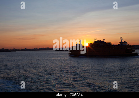 Am frühen Morgen Passagiere auf der Staten Island Fähre sehen Sonnenaufgang über der Skyline von Red Hook von Brooklyn, New York. Stockfoto