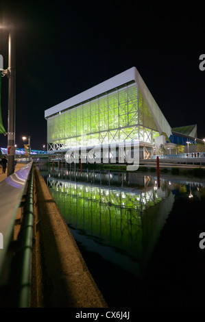 Nächtliches Bild des Aquatics Centre, reflektiert im Wasser des Flusses Lea, im Queen Elizabeth Olympic Park Stockfoto