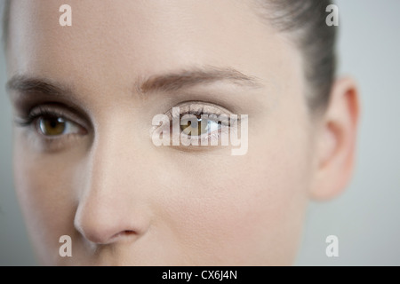 Eine junge Frau, die wegsehen, Fokus auf linke Auge Stockfoto