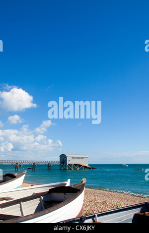 Boote am Strand von Selsey mit Rettungsstation in den Hintergrund, West Sussex, UK. Stockfoto