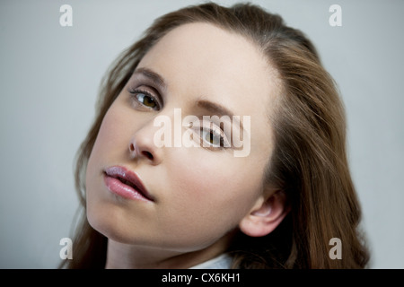 Profil von eine junge Brünette Frau mit dem Kopf wandte sich an Kamera Stockfoto