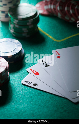 Eine Hand von Karten, die vier Asse, Glücksspiel Chips im Hintergrund anzeigen Stockfoto