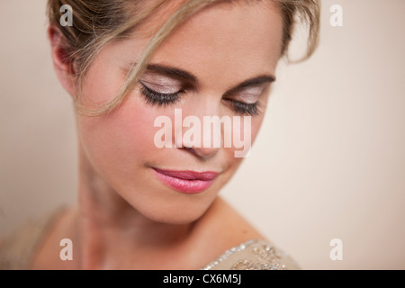 Eine junge Frau mit ihrem Haar, Blick nach unten Stockfoto