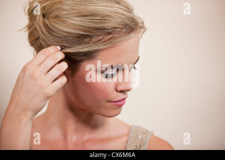 Eine junge Frau ihr Haar hinter ihr Ohr stopfte Stockfoto