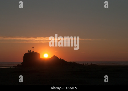 Menschen auf der Kapelle Rock, Dünenwanderungen Strand, Perranporth, Cornwall, UK. Sonnenuntergang. Juli. Flut heraus. Stockfoto